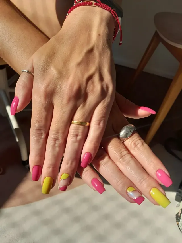 Esmaltação em gel rosa e amarelo com detalhe dourado, trabalho real do Espaço Maura Cunha
